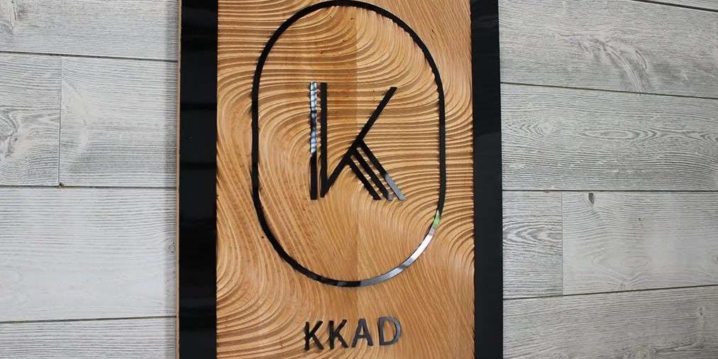 custom metal logo sign on wood.