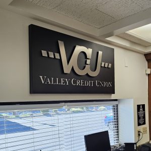 Custom metal sign layered and stencil cut for Valley Credit Union drive-up window wall.