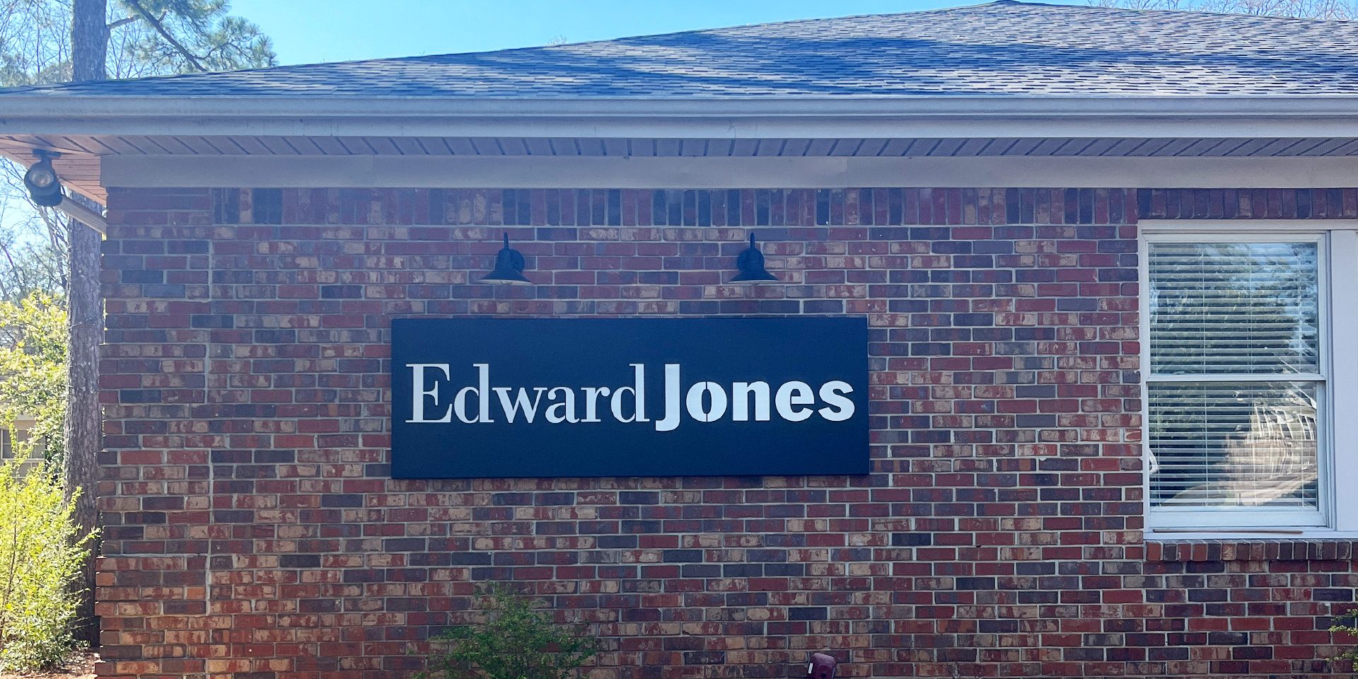 Custom metal box sign powder coated black with alluminum backplate on building exterior by Alabama Metal Art.