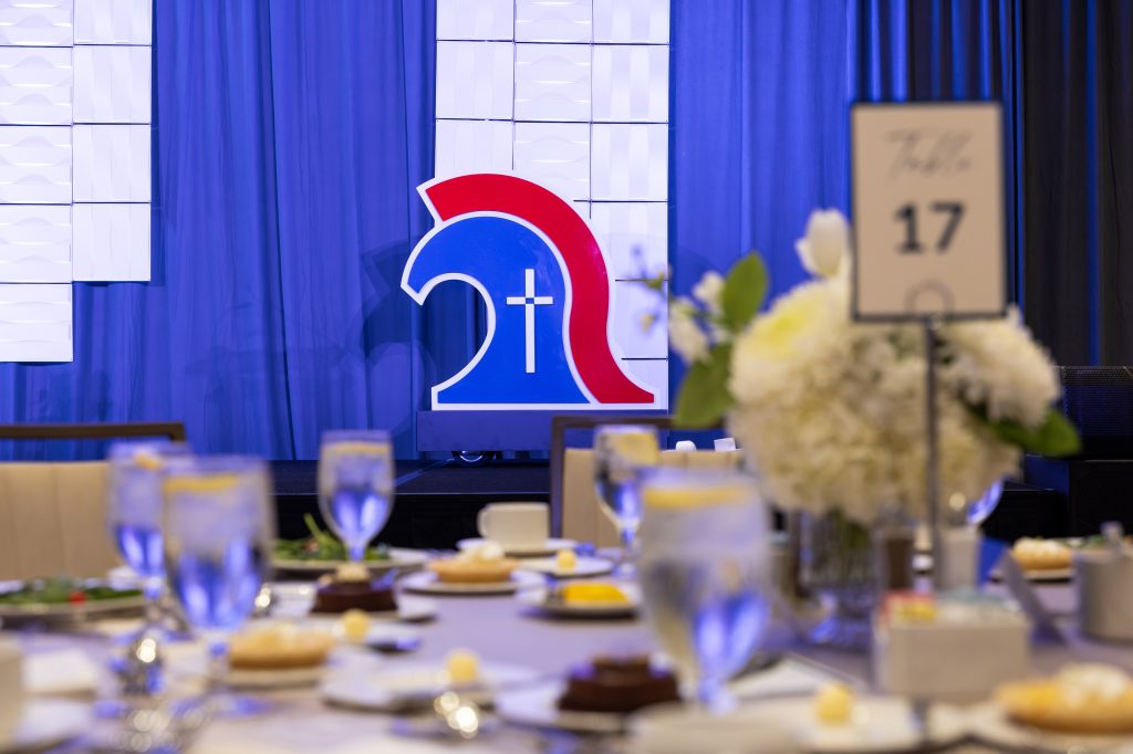 Mobile logo sign on stage at Trinity Christian Academy by Alabama Metal Art.