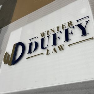 Close up of custom metal logo mounted to acrylic by Alabama Metal Art.