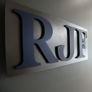 Close-up of custom metal raised single letters on a backplate.